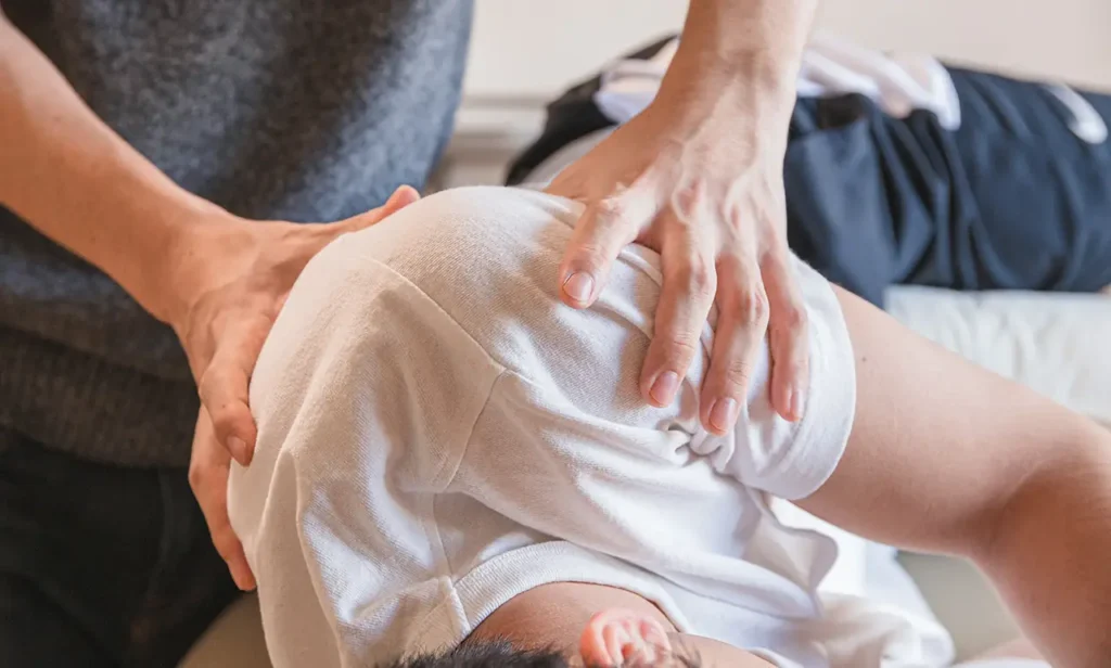 Le kinésithérapeute s'occupe d'un patient allongé sur le côté
